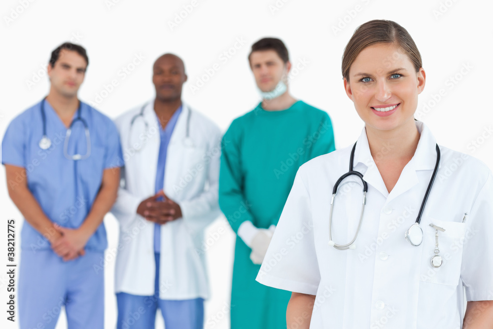 Female doctor with colleagues behind her Female doctor with colleagues behind her