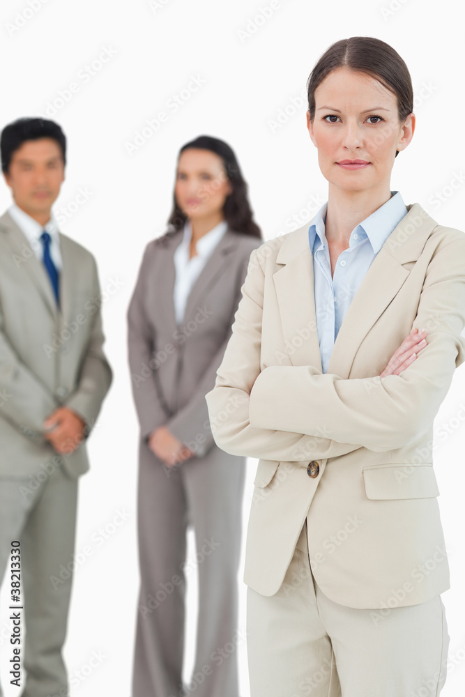 Confident tradeswoman with arms folded and team behind her Confident tradeswoman with arms folded and team behind her