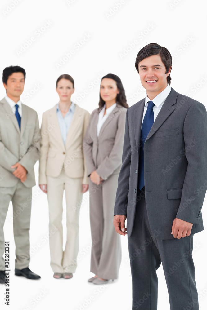 Smiling young salesman with team behind him Smiling young salesman with team behind him