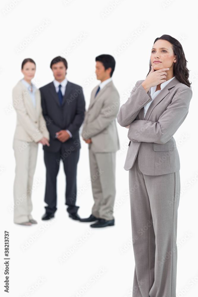 Thoughtful saleswoman with team behind her Thoughtful saleswoman with team behind her