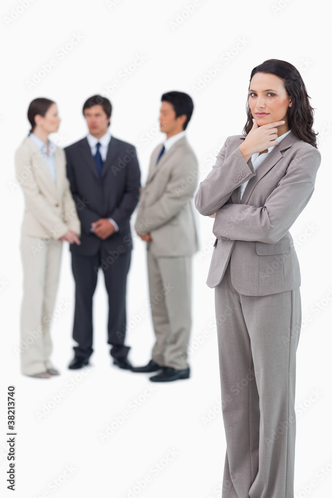 Thinking saleswoman with team behind her Thinking saleswoman with team behind her