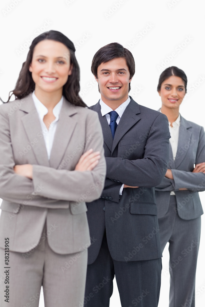 Smiling young salesteam standing together with arms folded Smiling young salesteam standing together with arms folded