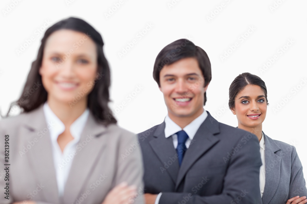 Smiling young salesteam standing together with folded arms Smiling young salesteam standing together with folded arms
