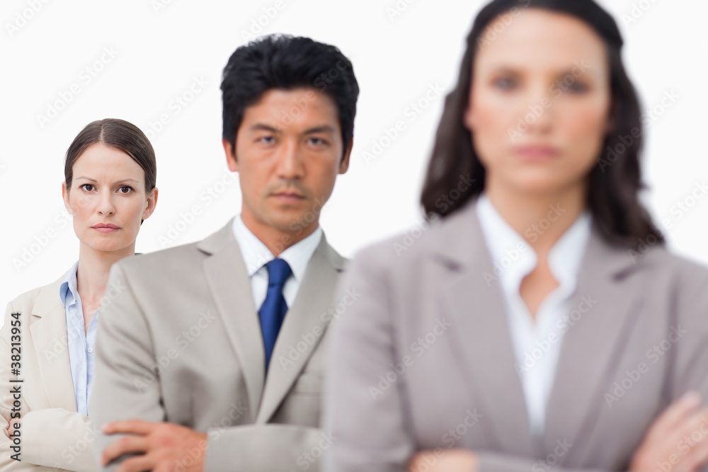 Serious salesteam standing with arms folded Serious salesteam standing with arms folded