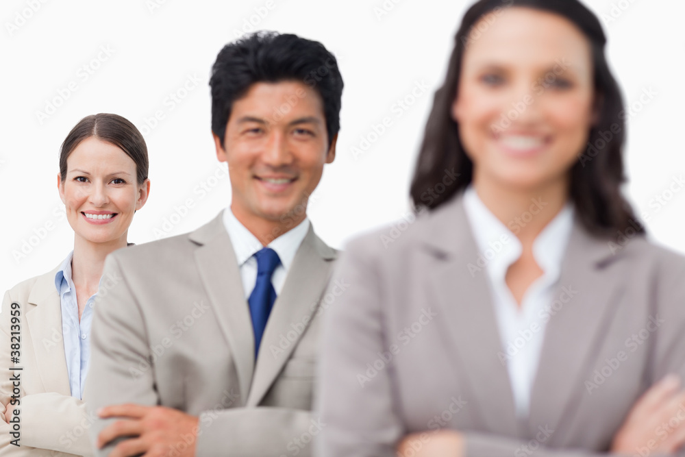 Smiling salesteam standing with arms folded Smiling salesteam standing with arms folded