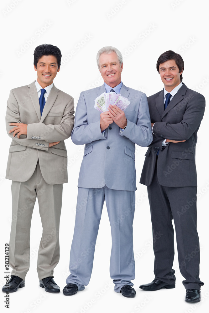 Smiling senior salesman with money and employees Smiling senior salesman with money and employees
