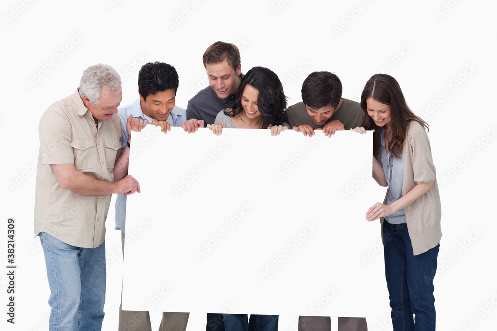 Group looking at blank sign in their hand Group looking at blank sign in their hand