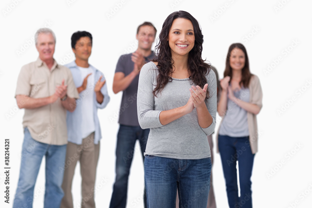 Clapping young woman with friends behind her Clapping young woman with friends behind her
