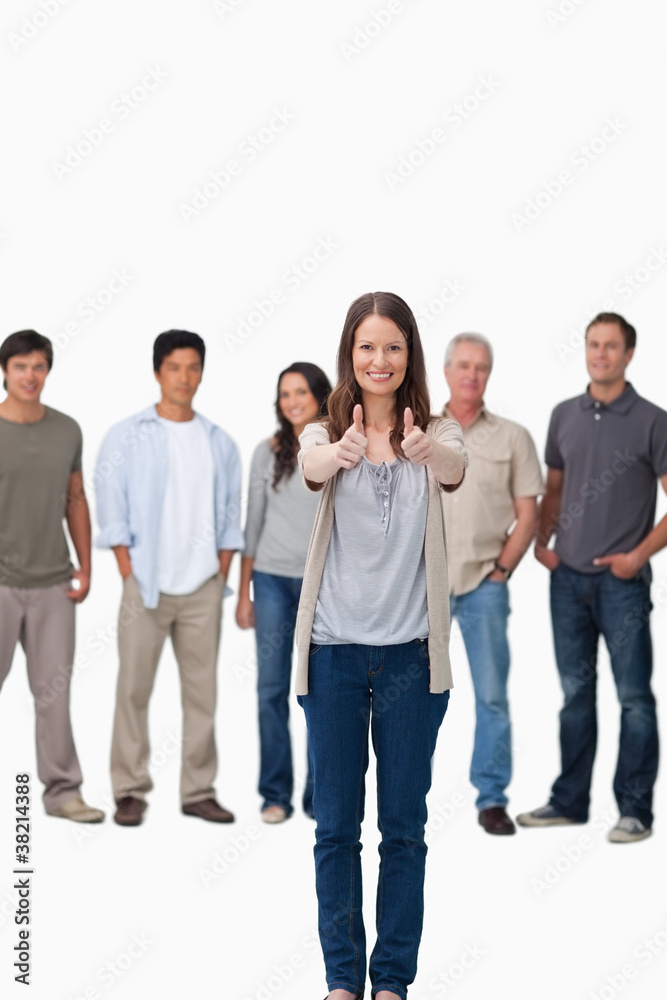 Approval given by smiling woman with friends behind her Approval given by smiling woman with friends behind her