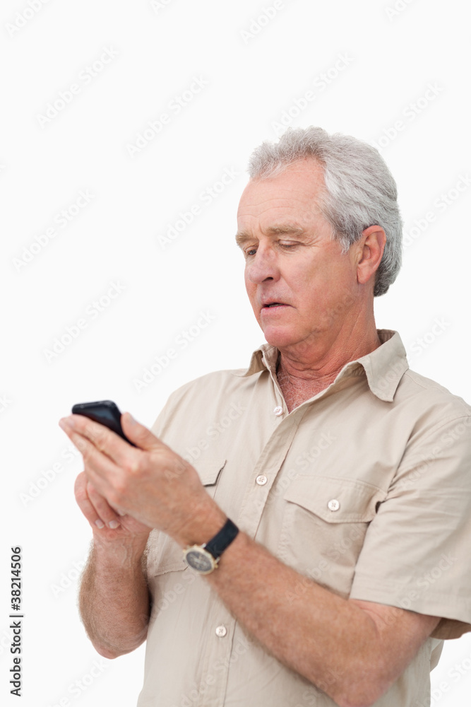Mature man typing text message on his cellphone Mature man typing text message on his cellphone