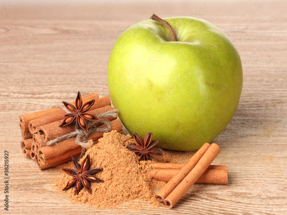 Cinnamon sticks, green apple and anise on wooden table Cinnamon sticks, green apple and anise on wooden table