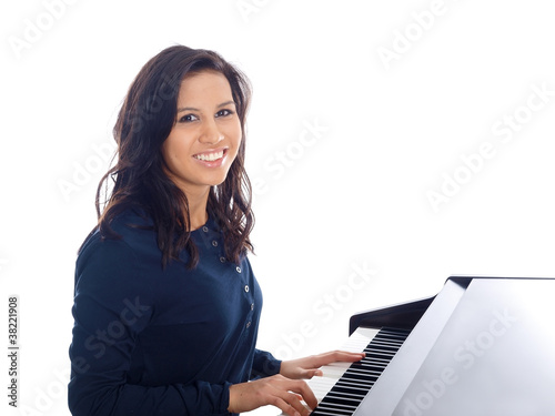 smiling teenage girl playing piano