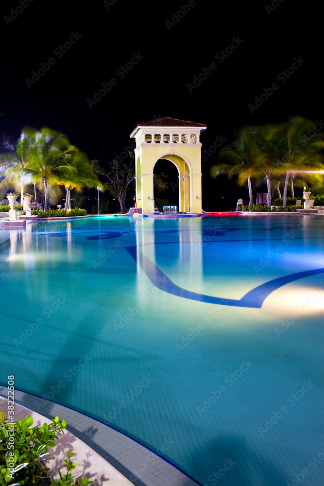 Night pavilion behind pool