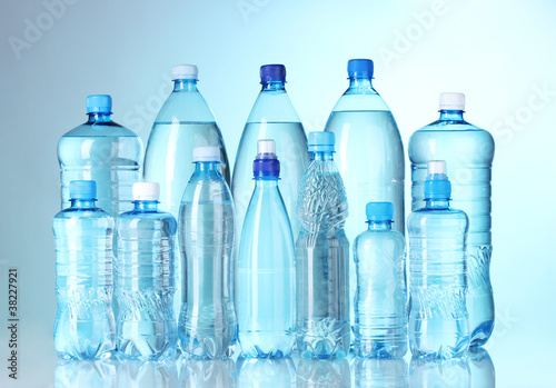 Group plastic bottles of water on blue background
