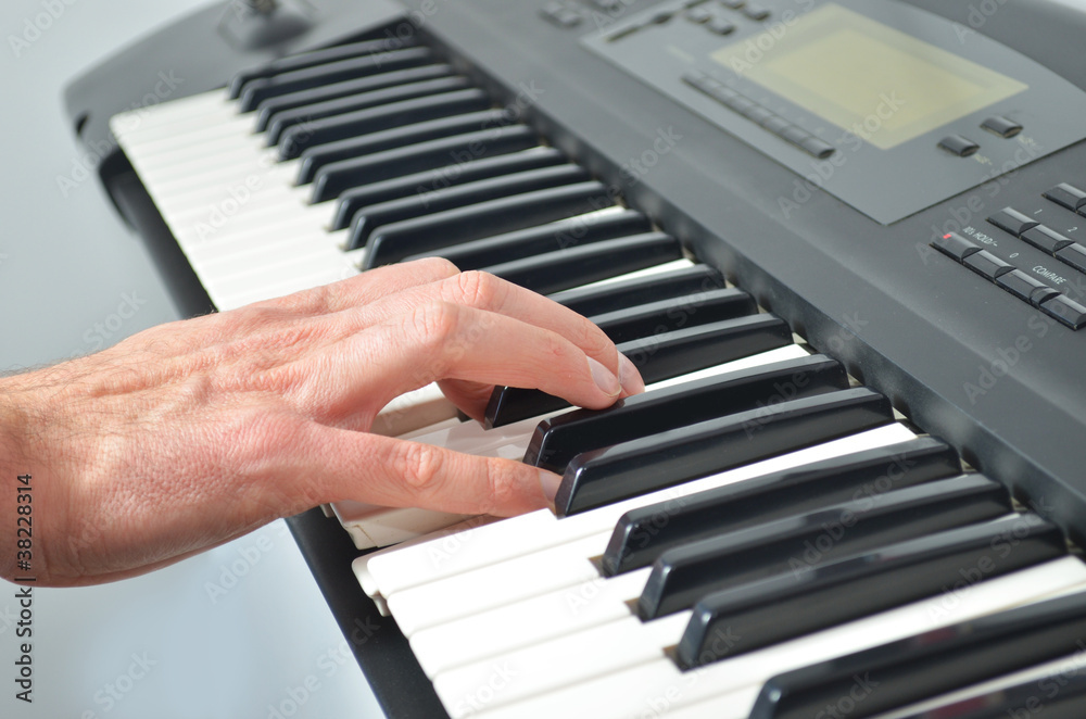 Hand playing electronic keyboard Hand playing electronic keyboard