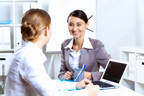 Young women in business wear working in office