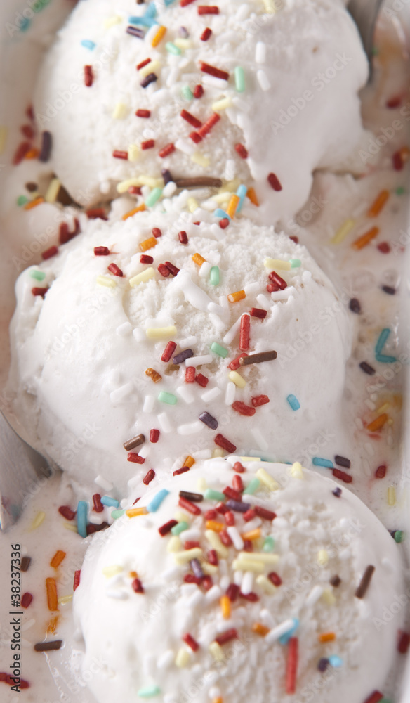 scoops of vanilla ice cream in bowl with sprinkles scoops of vanilla ice cream in bowl with sprinkles