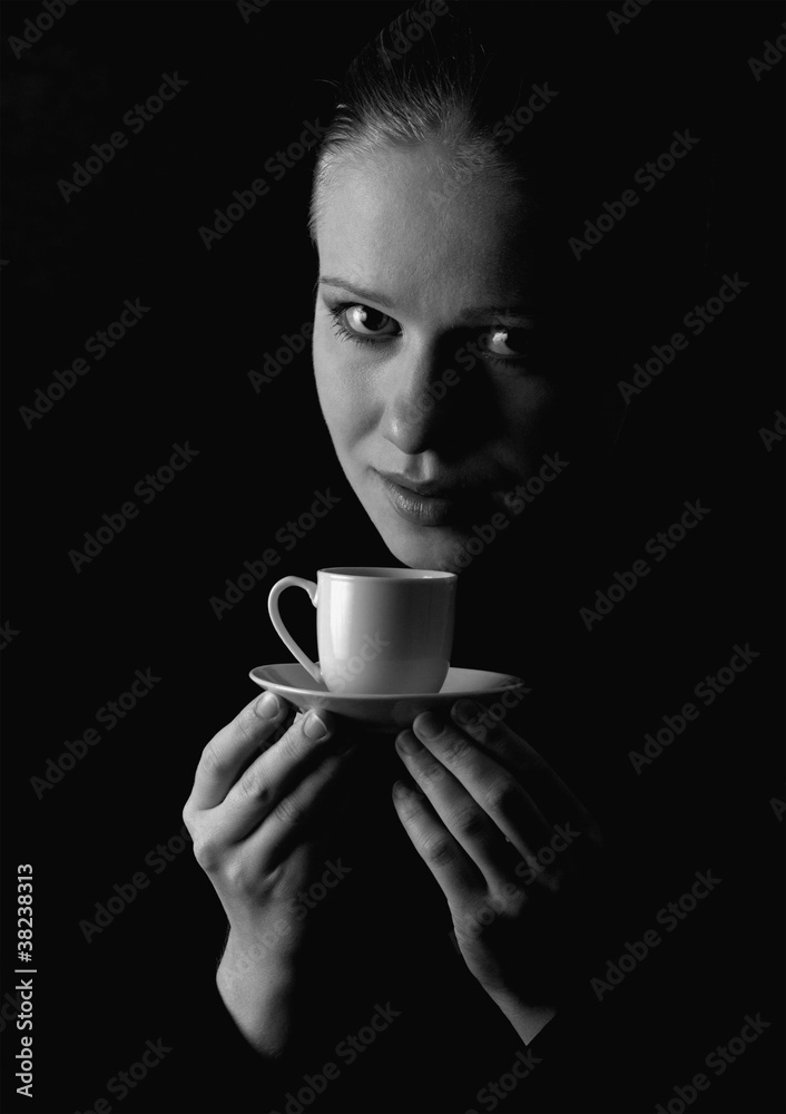 beautiful girl with a cup of coffee on a black background