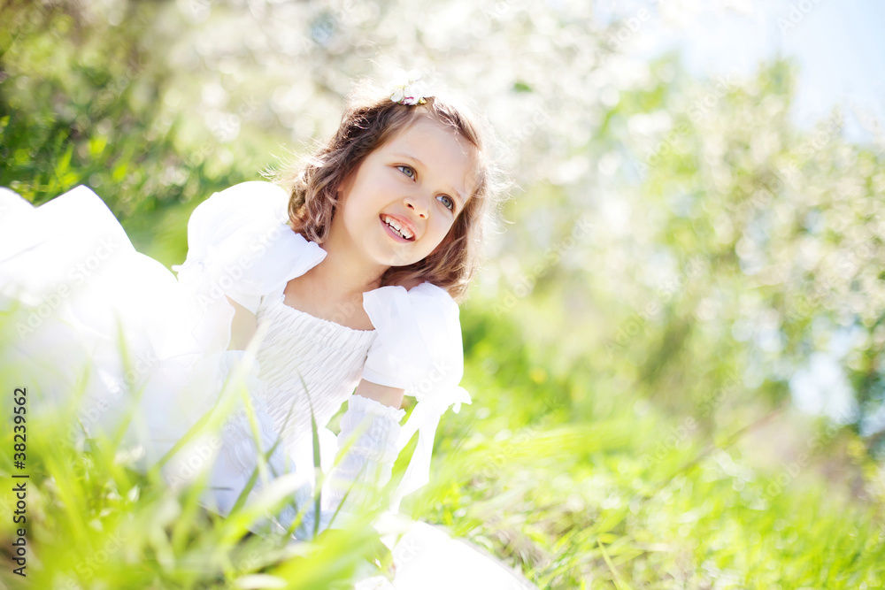 The beautiful little girl, with bush blossoming apple-tree, smil The beautiful little girl, with bush blossoming apple-tree, smil