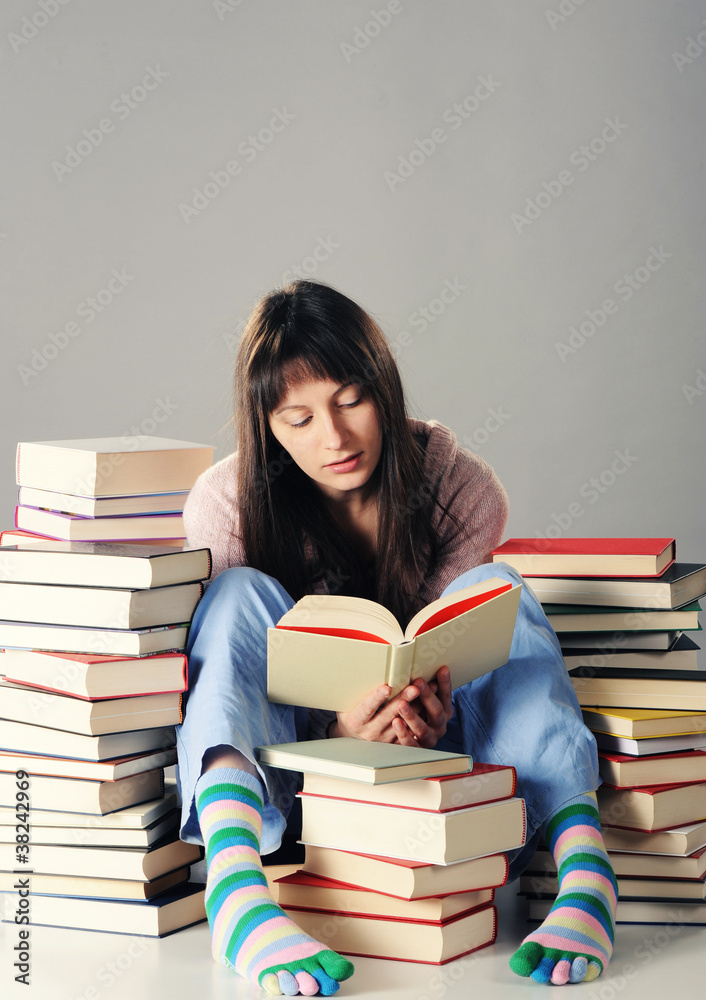 Cute girl studying with a big stack of books Cute girl studying with a big stack of books