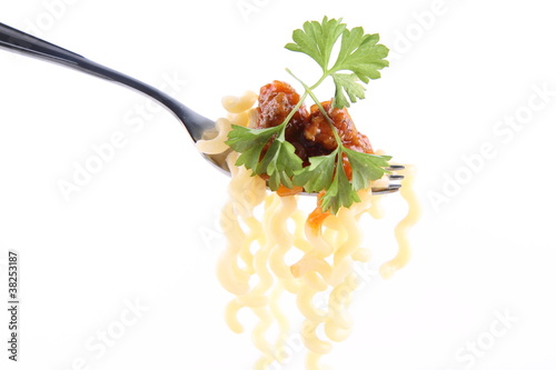 Fusilli bolognese decorated with parsley on a fork