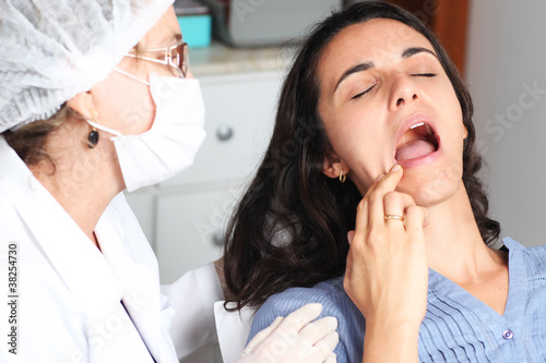 Patientin zeigt Zahnarzt wo es weh tut