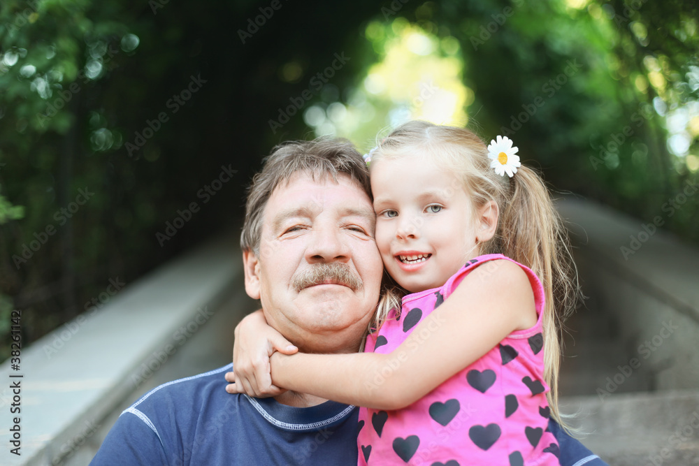 Portrait of grandfather with granddaughter outdoor