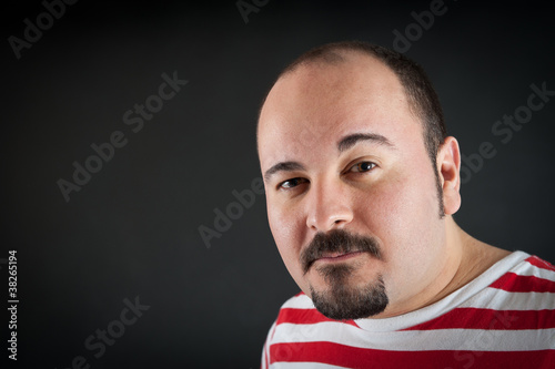 Man portrait with interdicted expression on dark background.