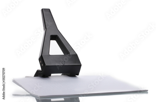 Black office hole punch with paper isolated on white © Africa Studio