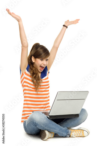 Woman with arms raised using laptop © pikselstock