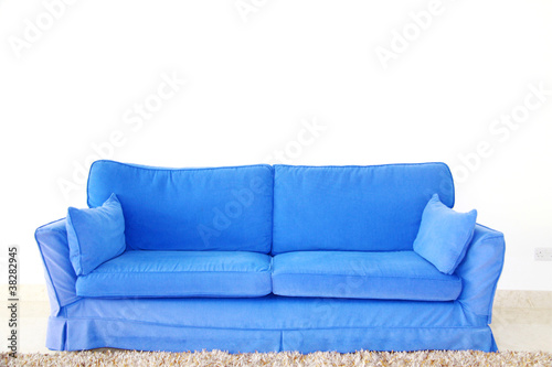 blue double sofa on a blank wall