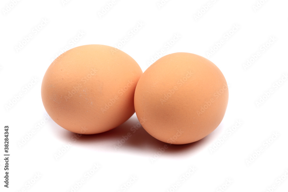Zwei braune Eier vor weißem Hintergrund