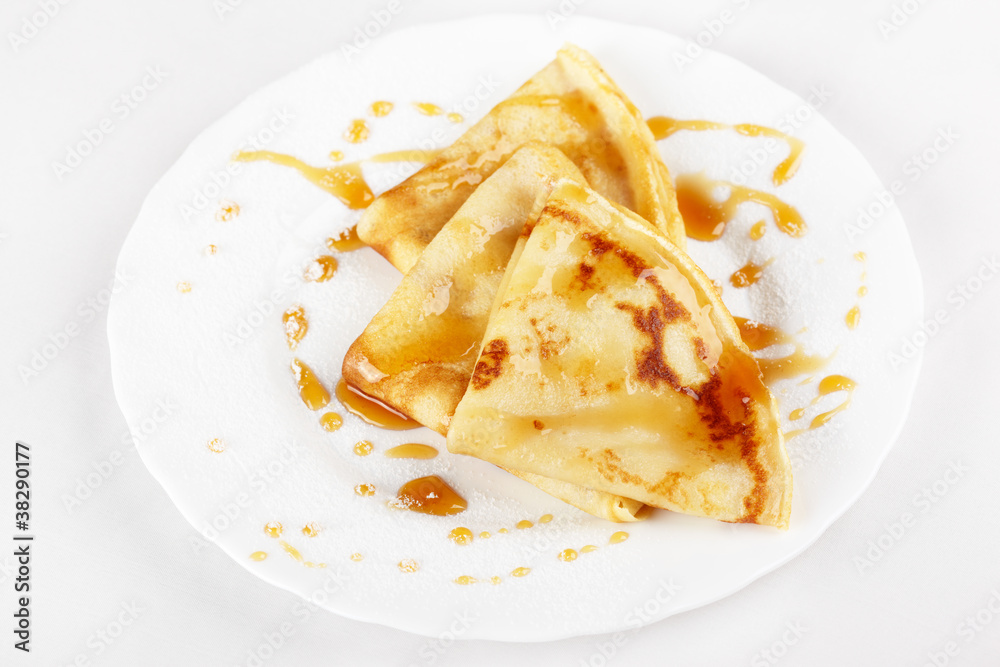 Thin pancakes with honey and powdered sugar