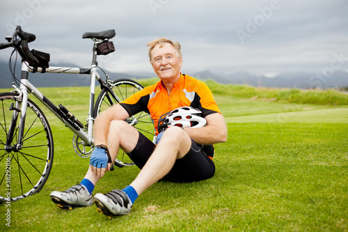 active senior bicyclist taking a break on the hill