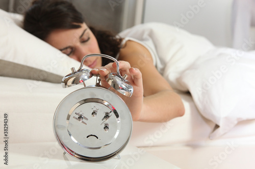Woman turning off alarm clock