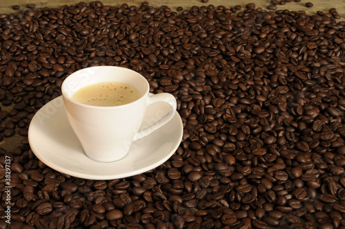 withe cup of coffee between beans