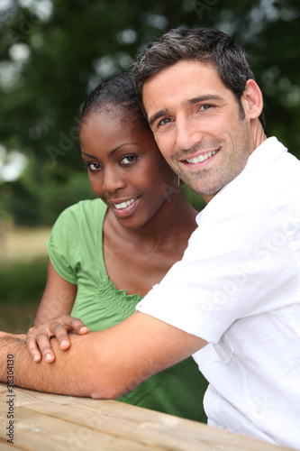 An interracial couple in a park.