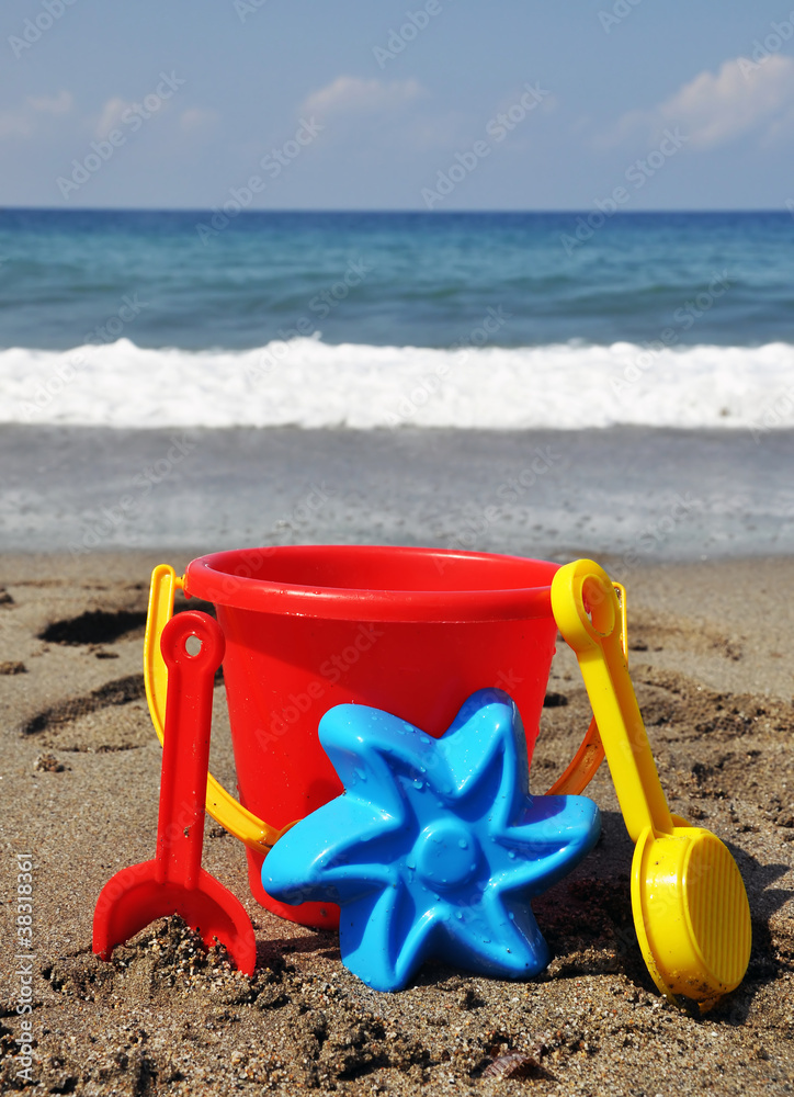 Children's beach toys - buckets, shovel on sand on a sunny day Children's beach toys - buckets, shovel on sand on a sunny day