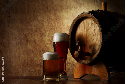Beer into glass on a old stone and old barrel