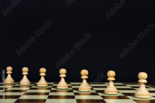 Playing pawns diagonally on a chessboard  black background