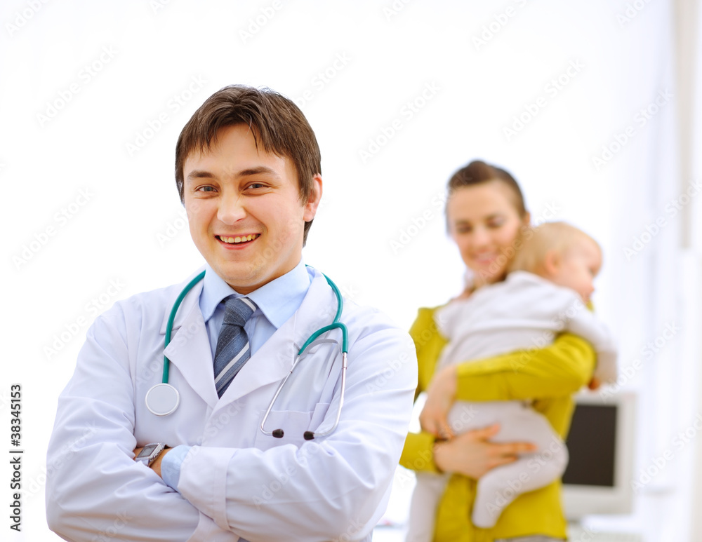 Pediatrician doctor and mother with baby in background Pediatrician doctor and mother with baby in background