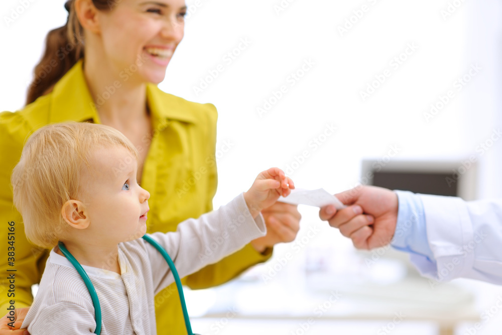 Mother and baby stretching for prescription in hand of pediatric