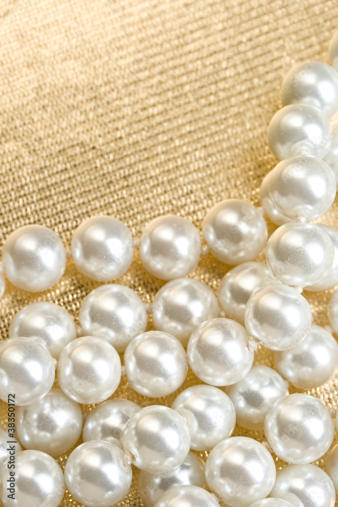 String of pearls on golden surface String of pearls on golden surface