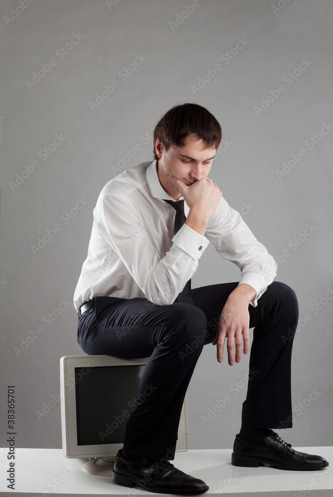 young man sitting on the monitor young man sitting on the monitor