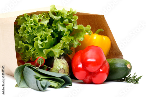 grocery bag full of vegetables isolated on white background