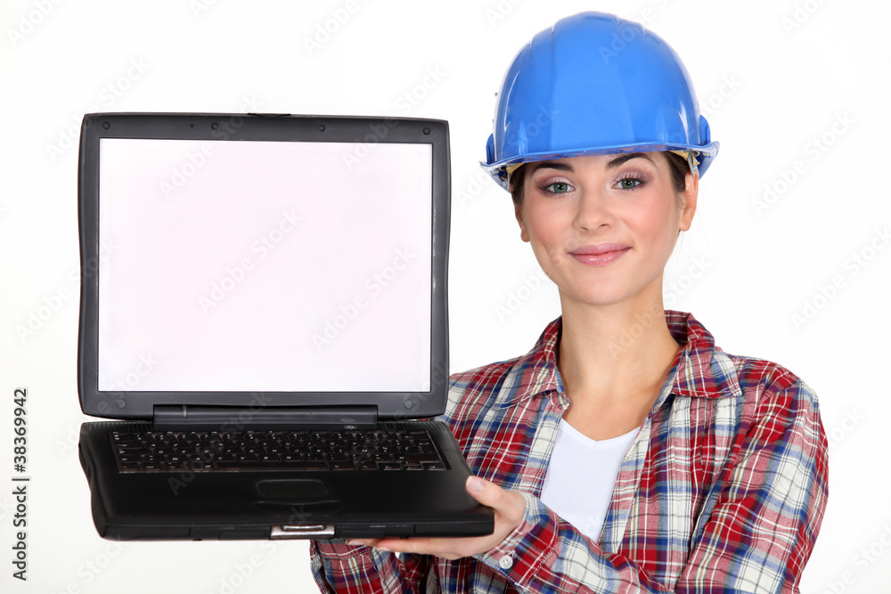 A female construction worker presenting a laptop. A female construction worker presenting a laptop.