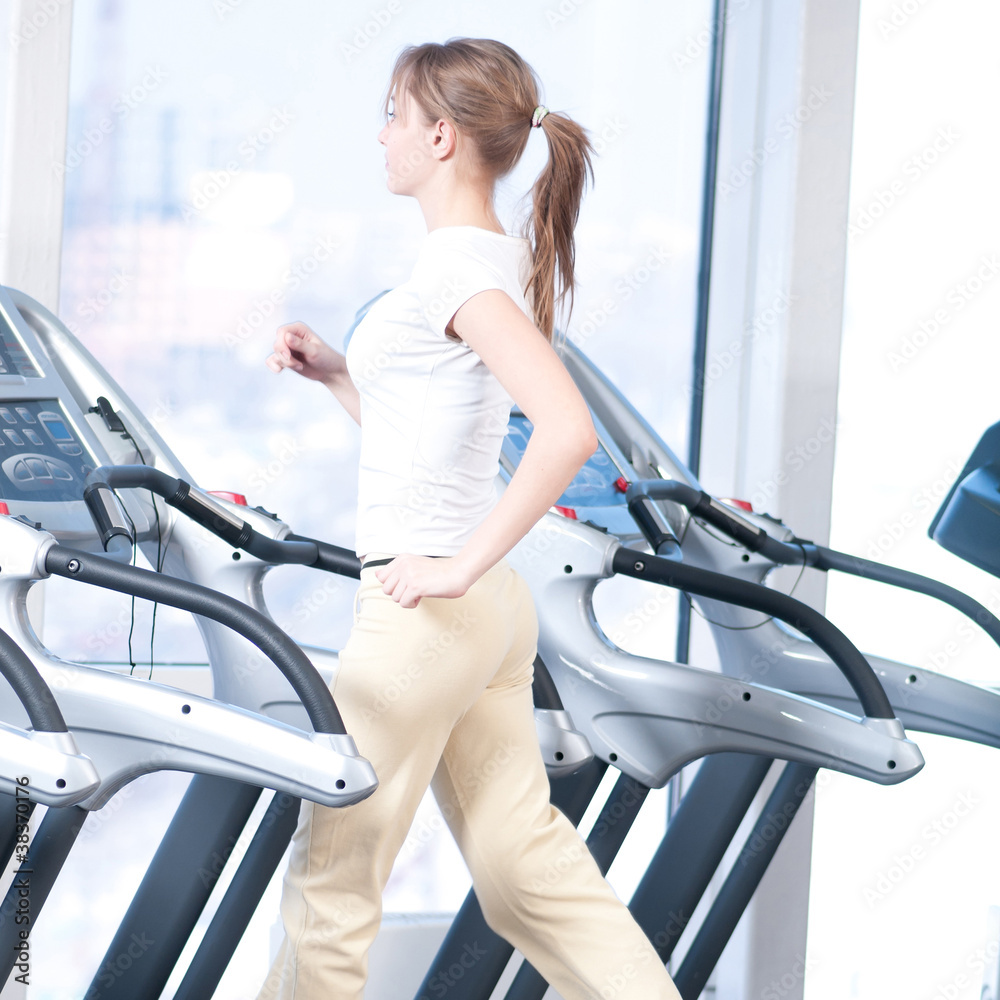 Young woman at the gym exercising. Running Young woman at the gym exercising. Running