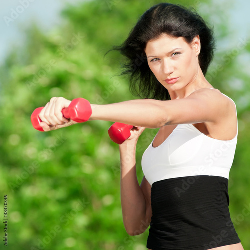 Woman doing exercise with dumbbell