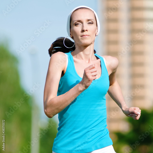Beautiful woman running in green park