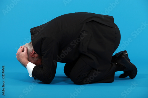 Businessman huddled on the floor